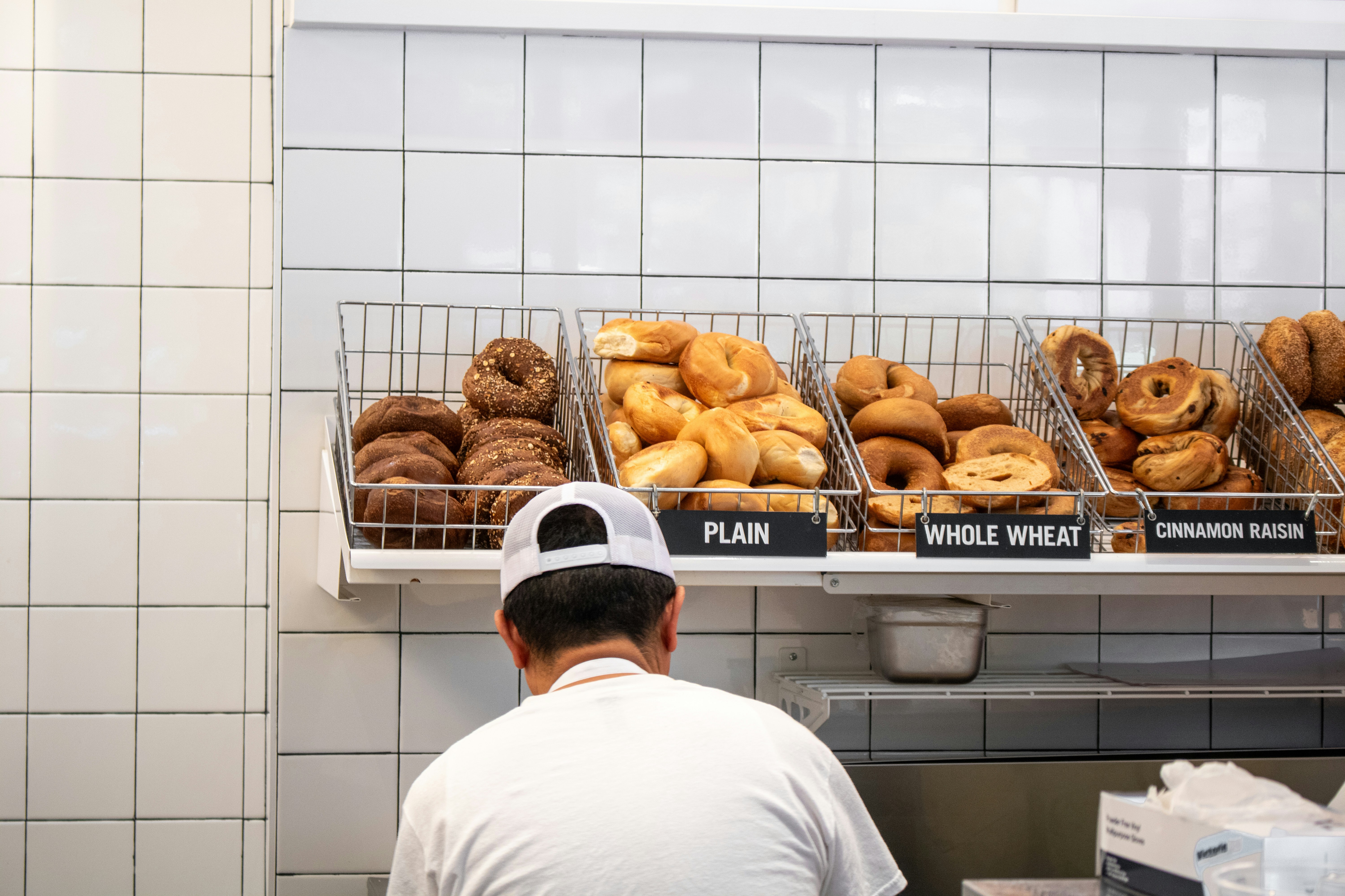 a man standing in front of a display of doughnuts, Kossar