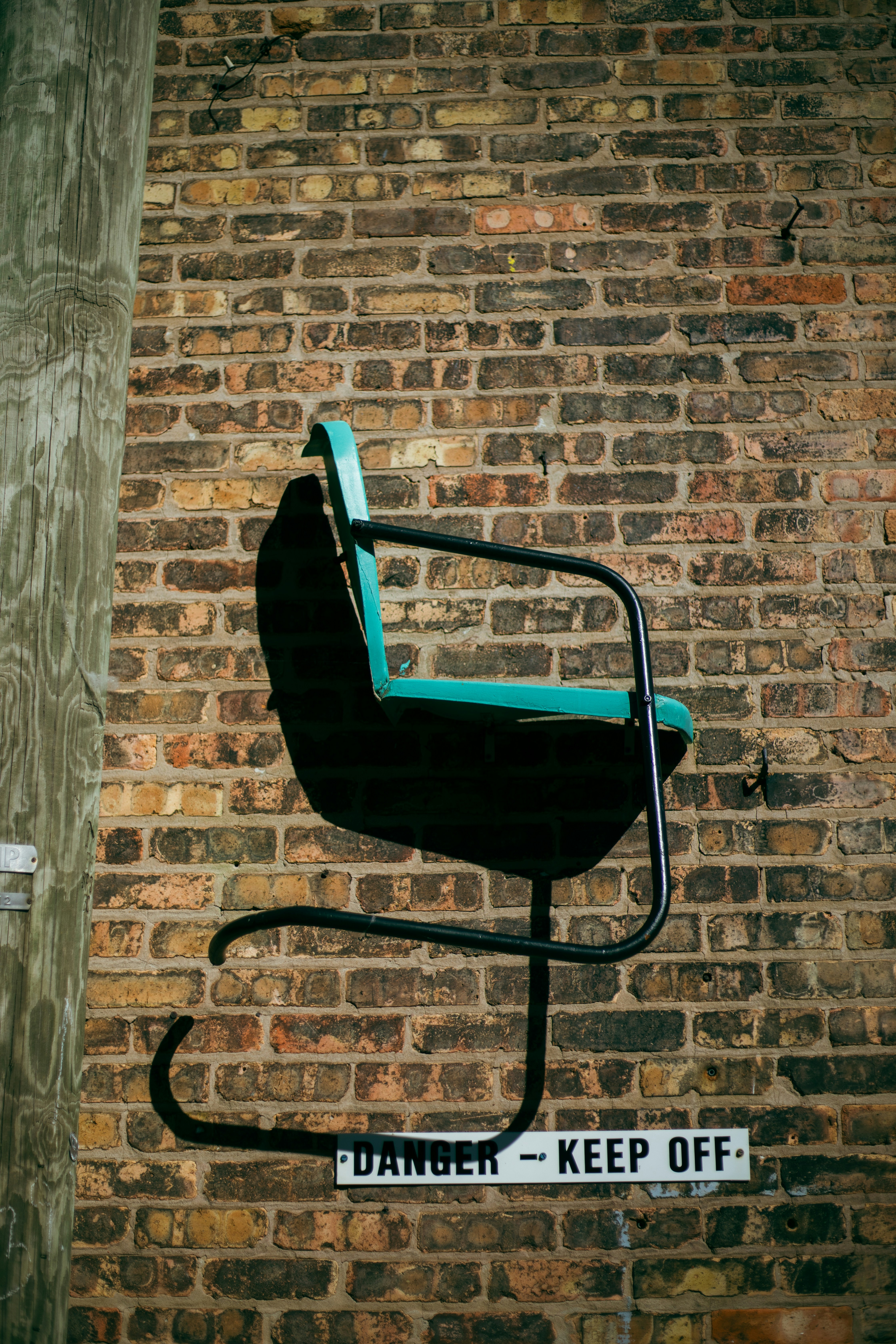 a blue chair sitting on top of a metal pole