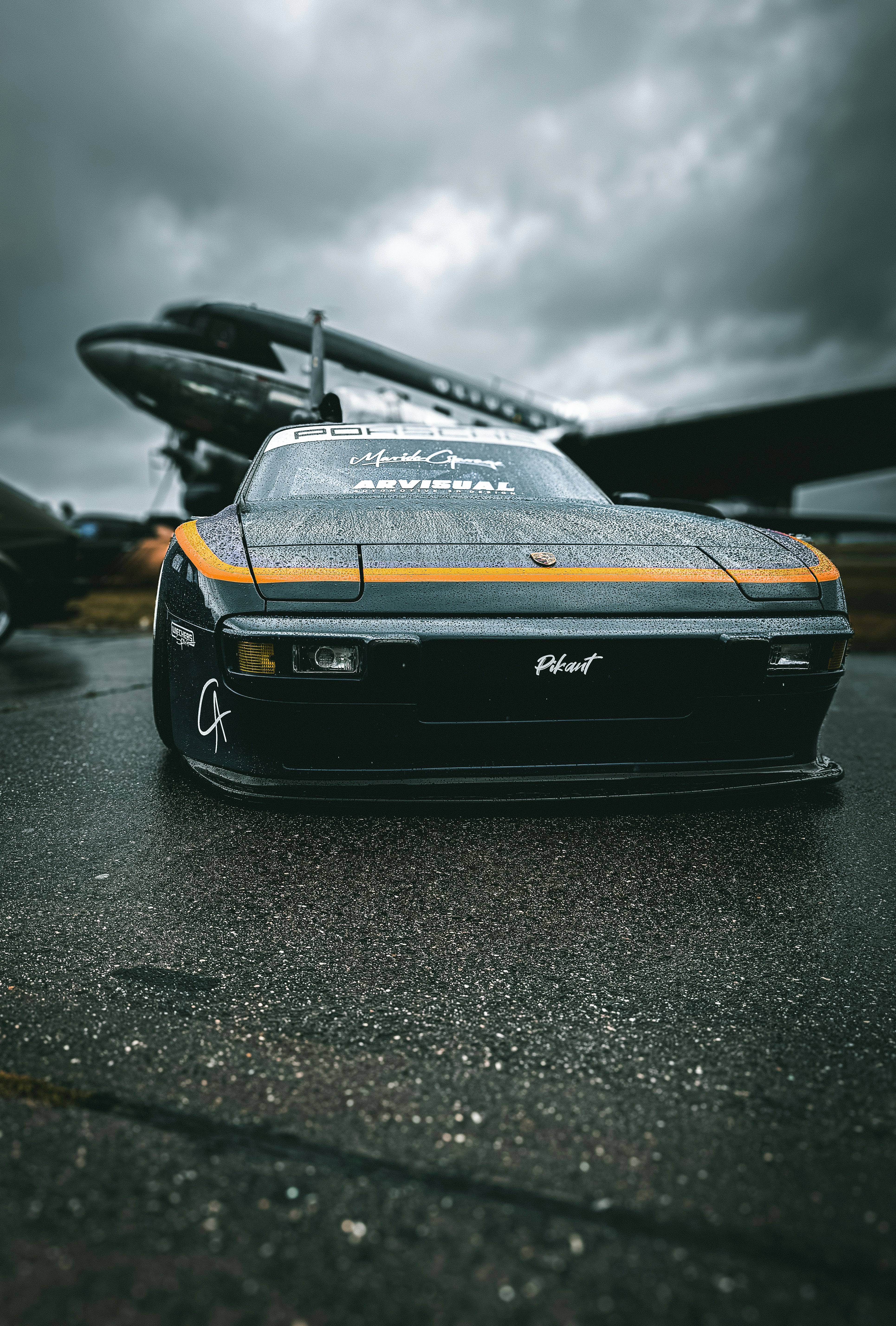 a car parked in front of an airplane
