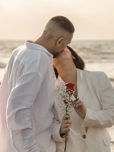 a man and a woman kissing on the beach