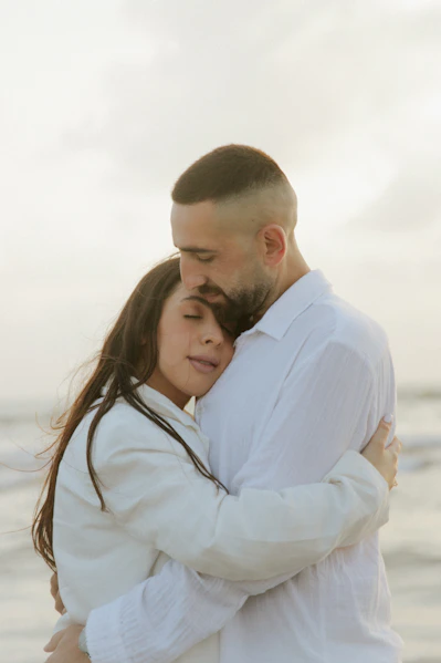 a man and a woman embracing on the beach