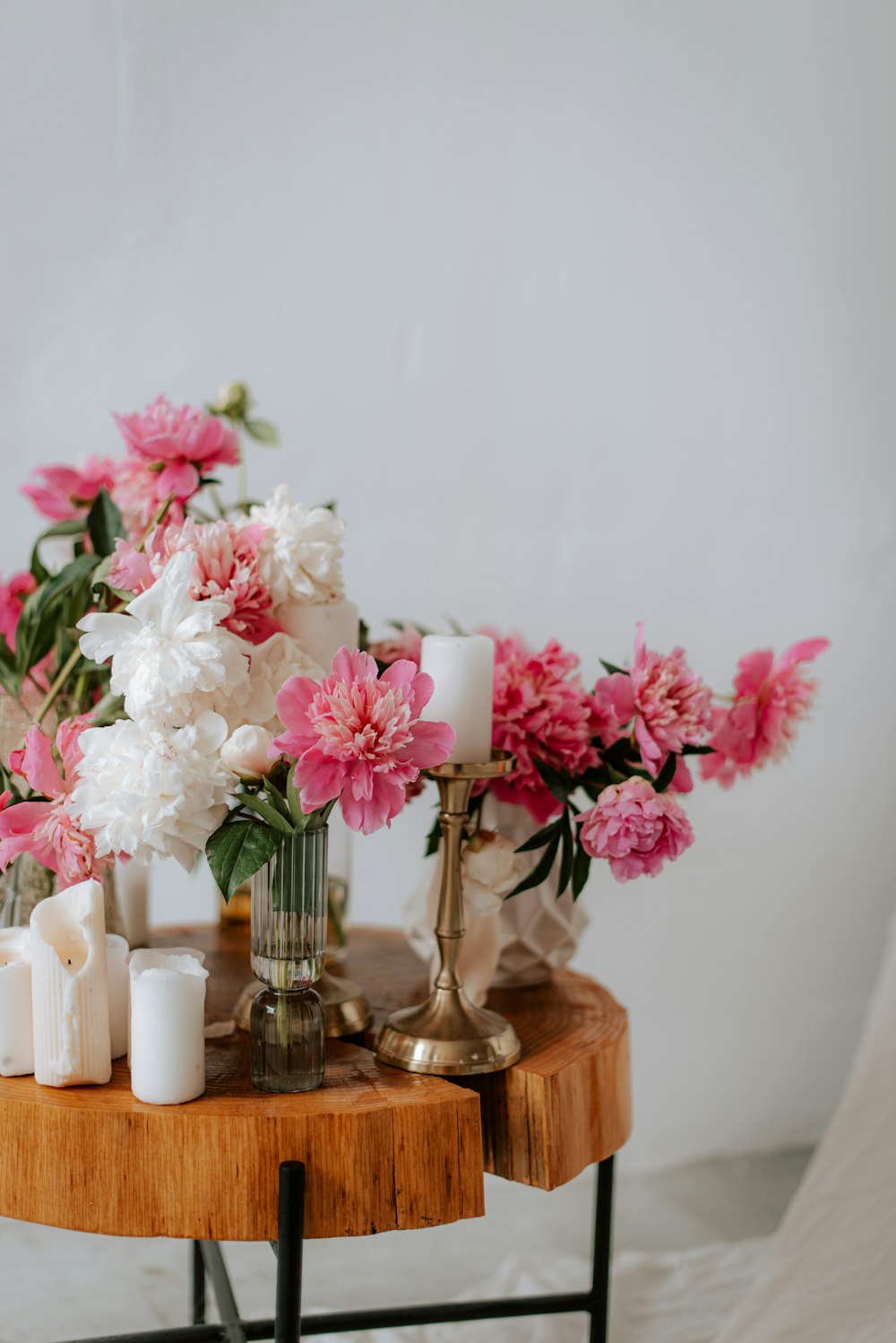 a wooden table topped with a vase filled with pink and white flowers