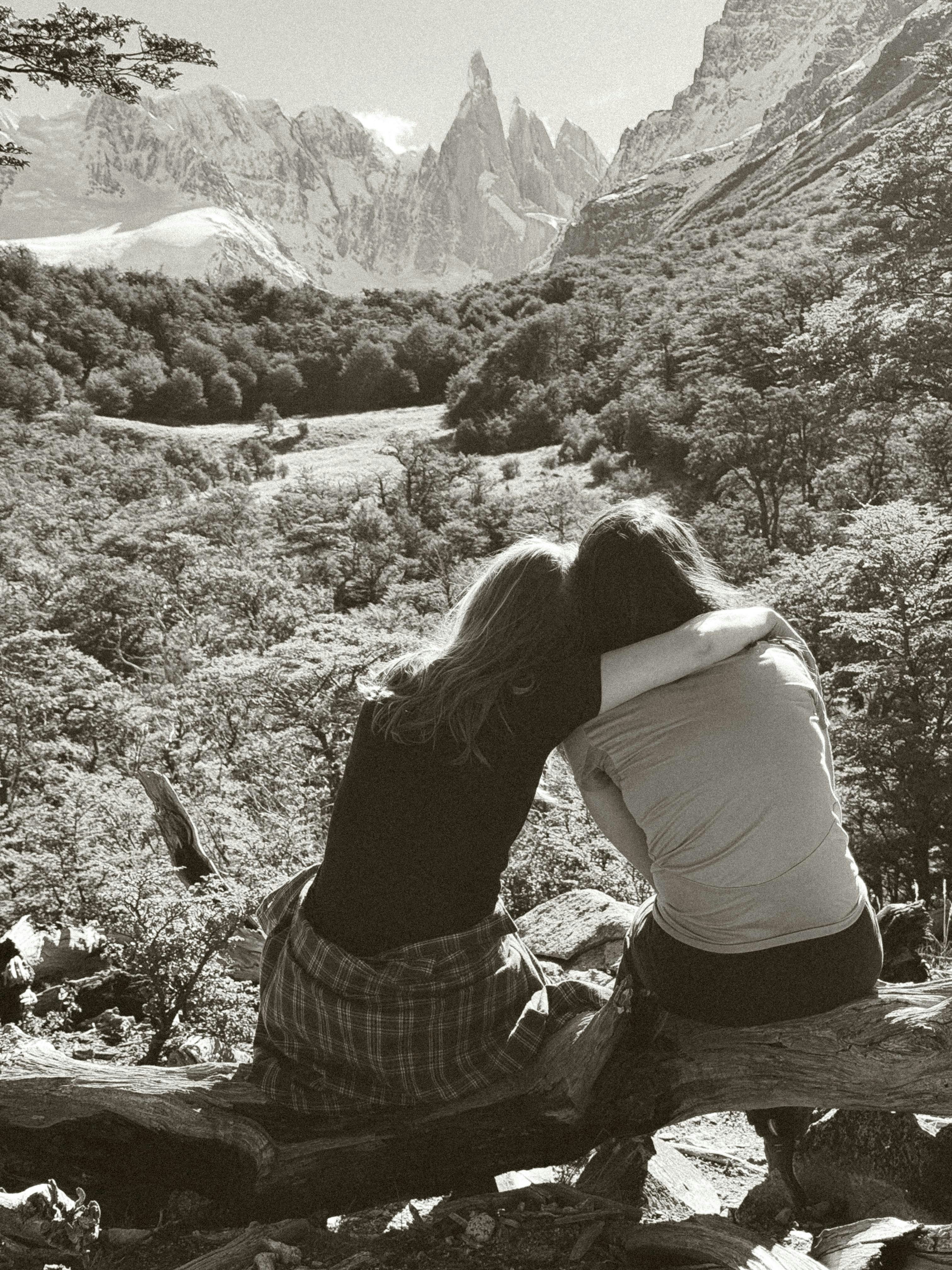 A couple of women sitting on top of a rock photo – Free Vacation Image ...