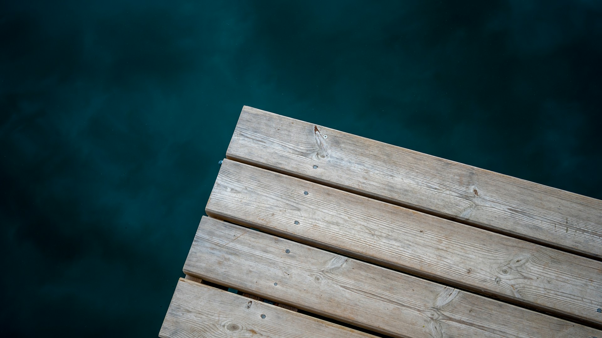 a close up of a wooden dock with water in the background