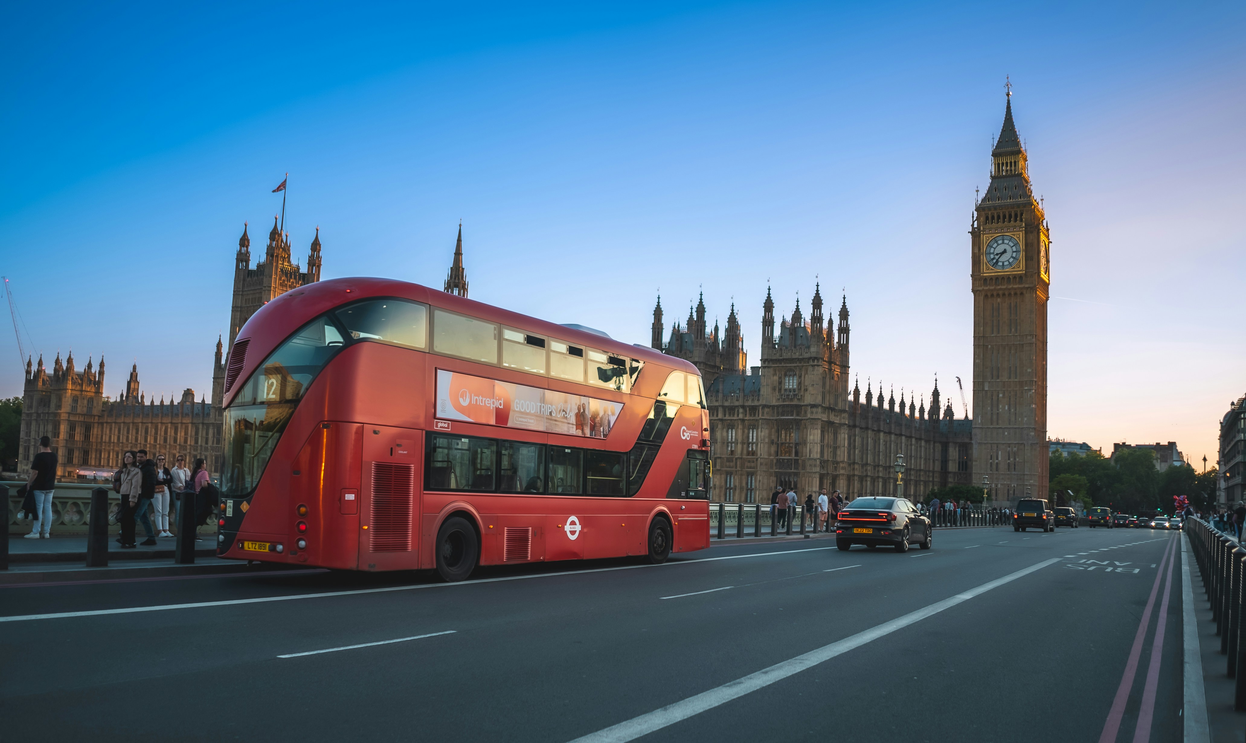 a red double decker bus driving down a street