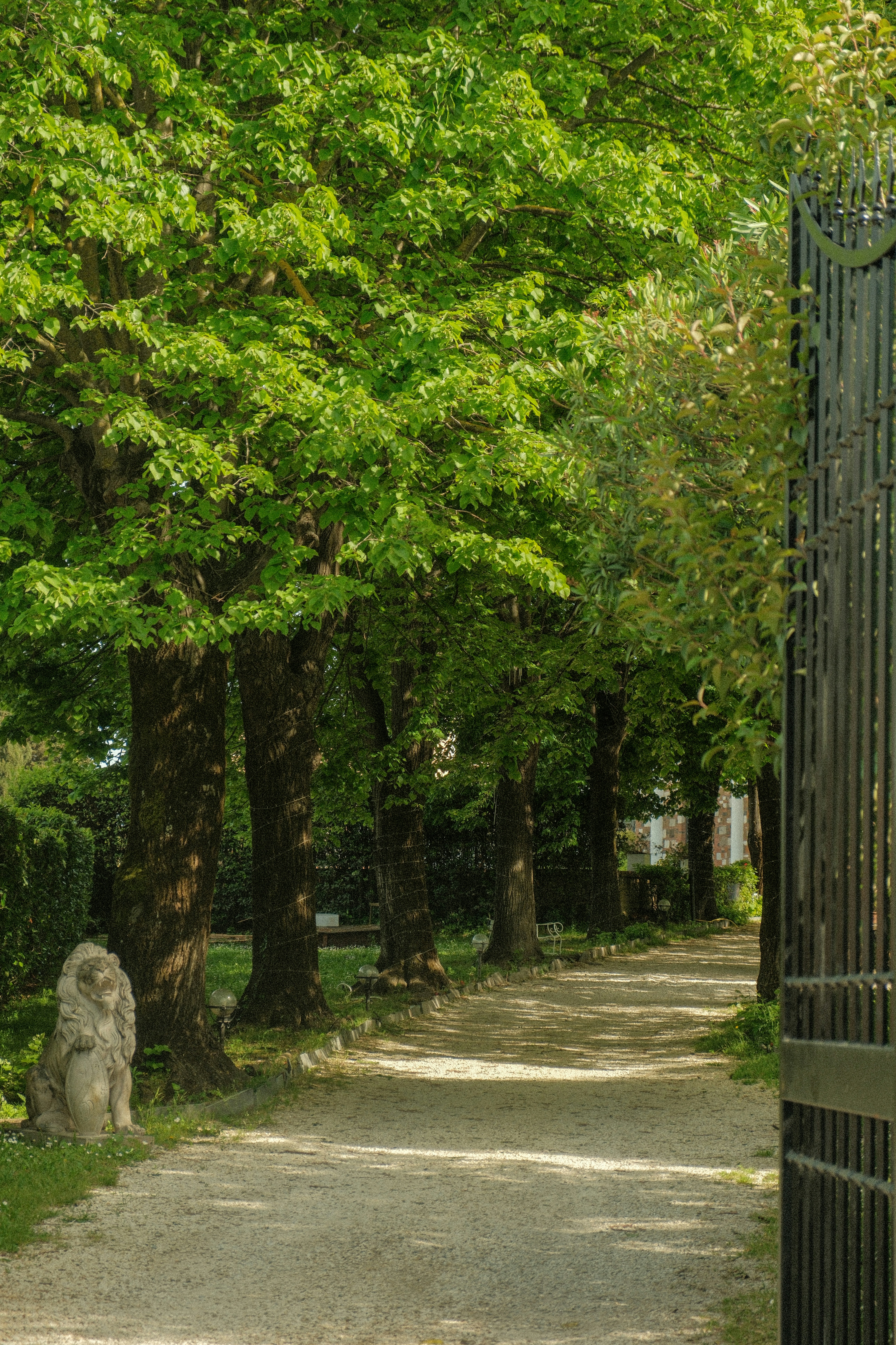 a stone lion statue sitting on the side of a road