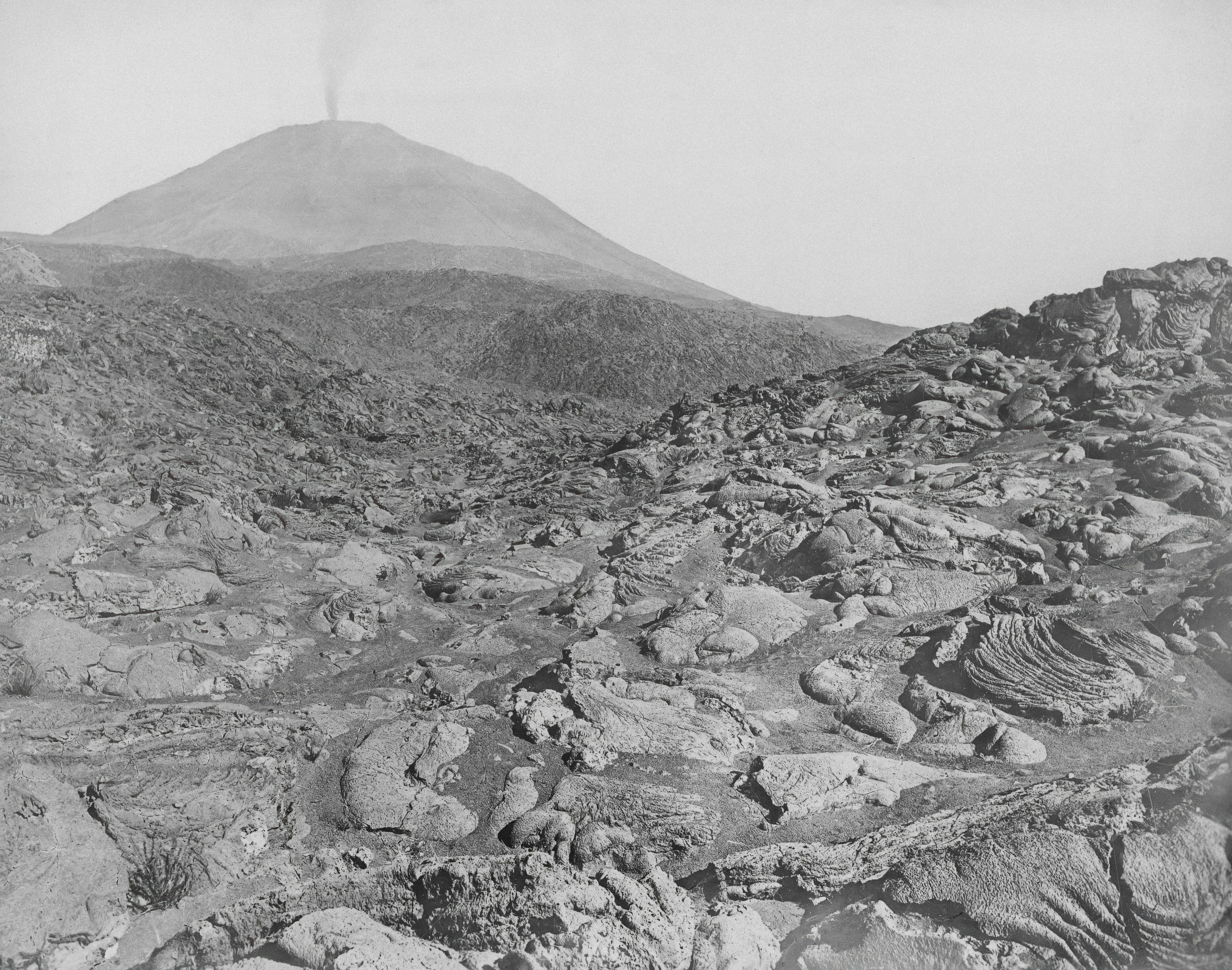 Volcanic landscape with a smoking cone in the distance