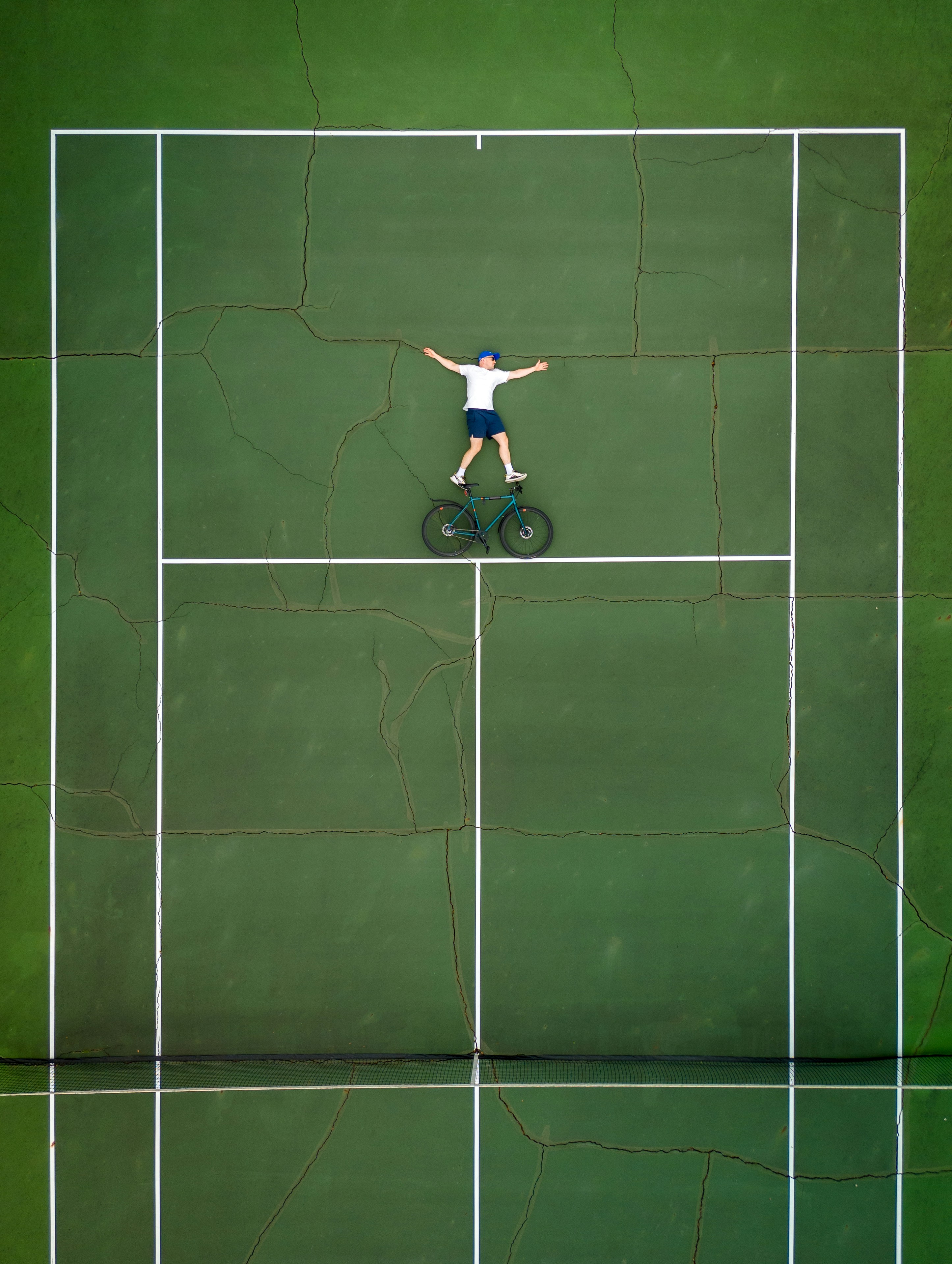 緑のコートでテニスをしている男性