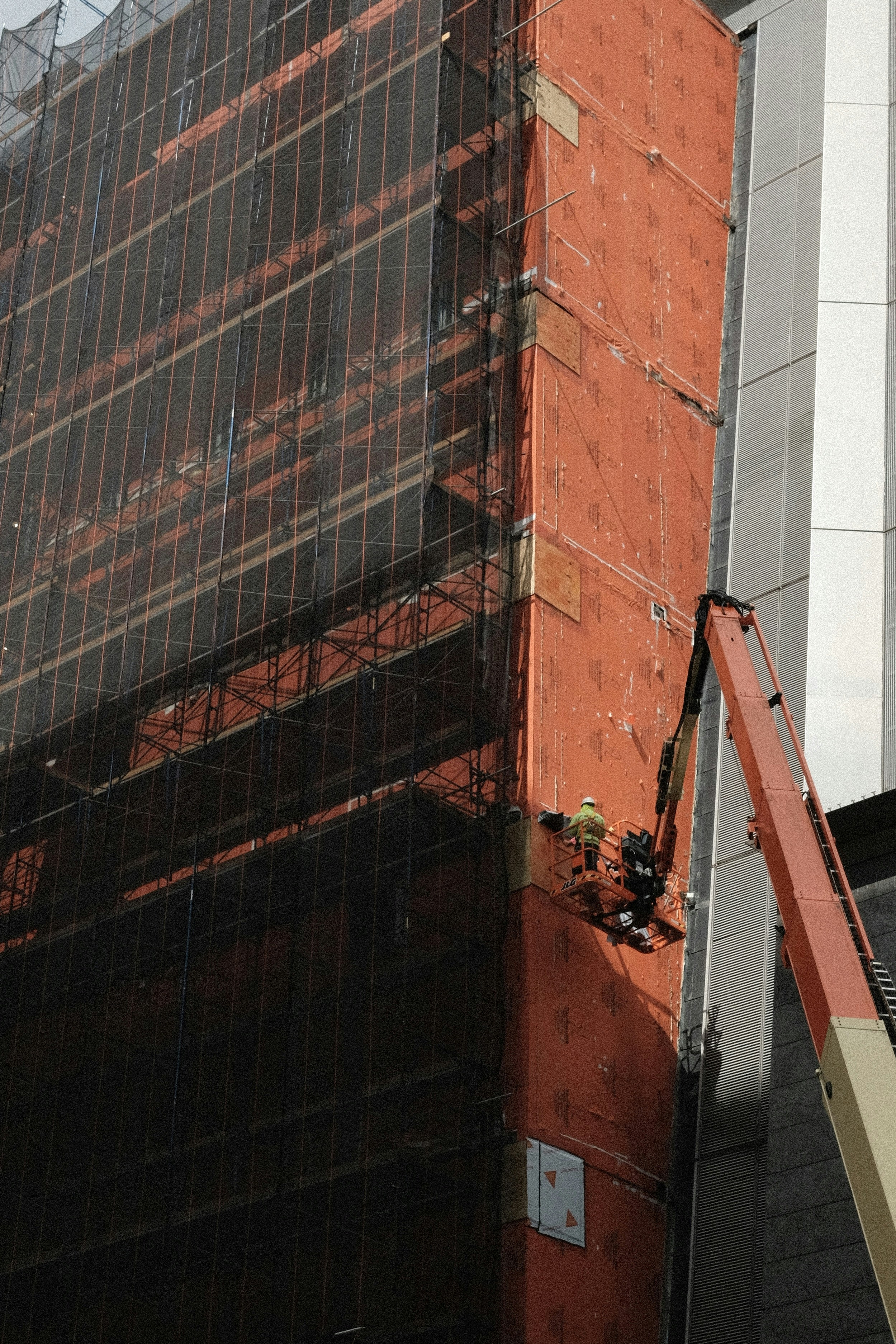 a crane is working on the side of a tall building