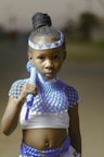 a young girl wearing a blue and white costume