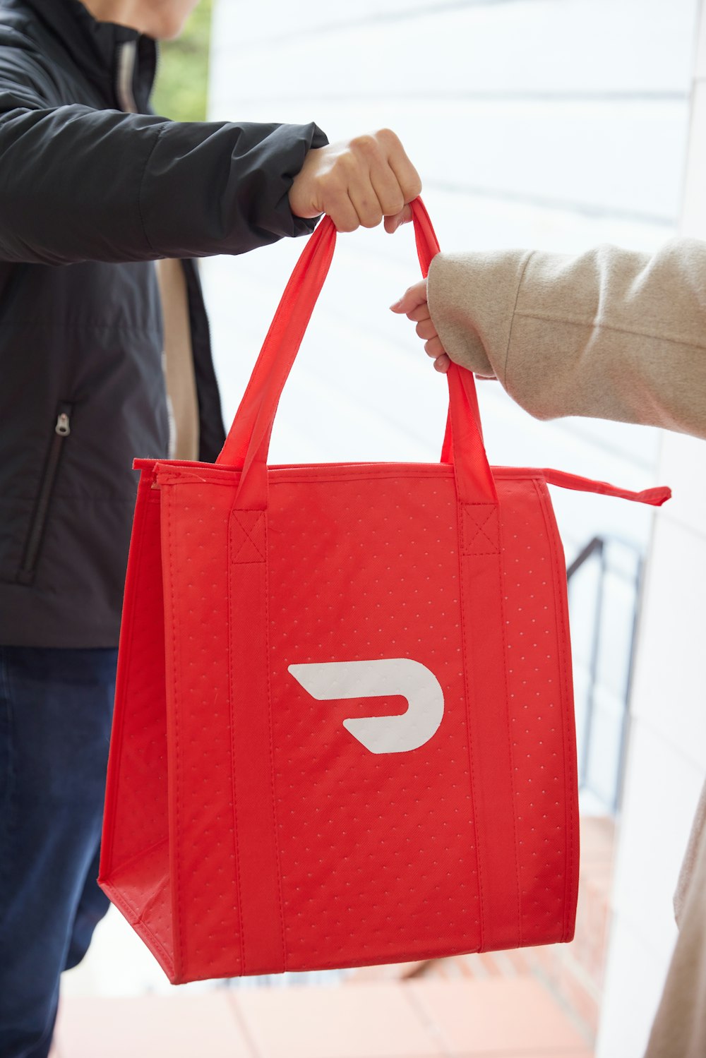 a person holding a red bag with the letter D on it