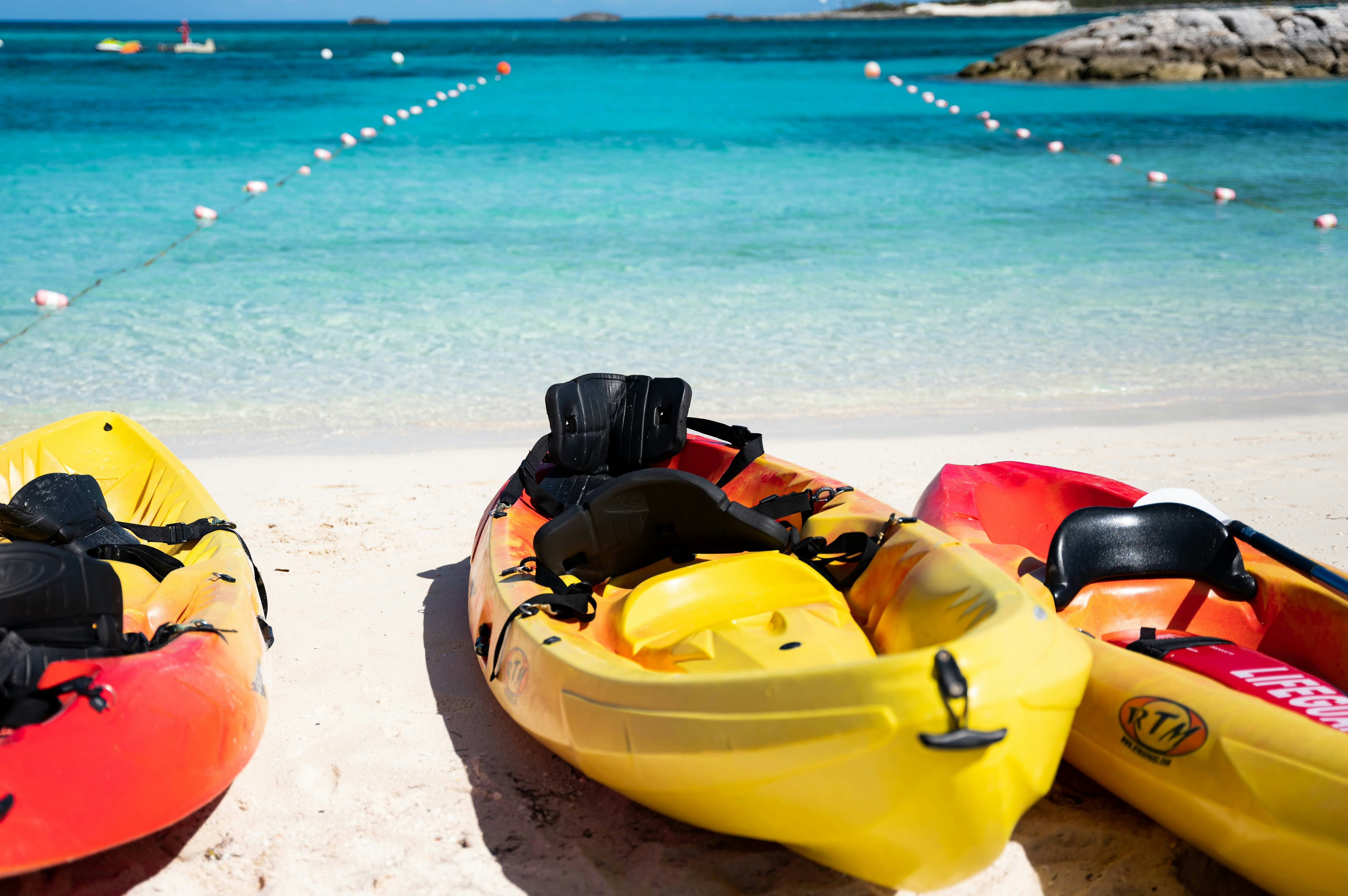 two kayaks sitting on the beach next to the ocean