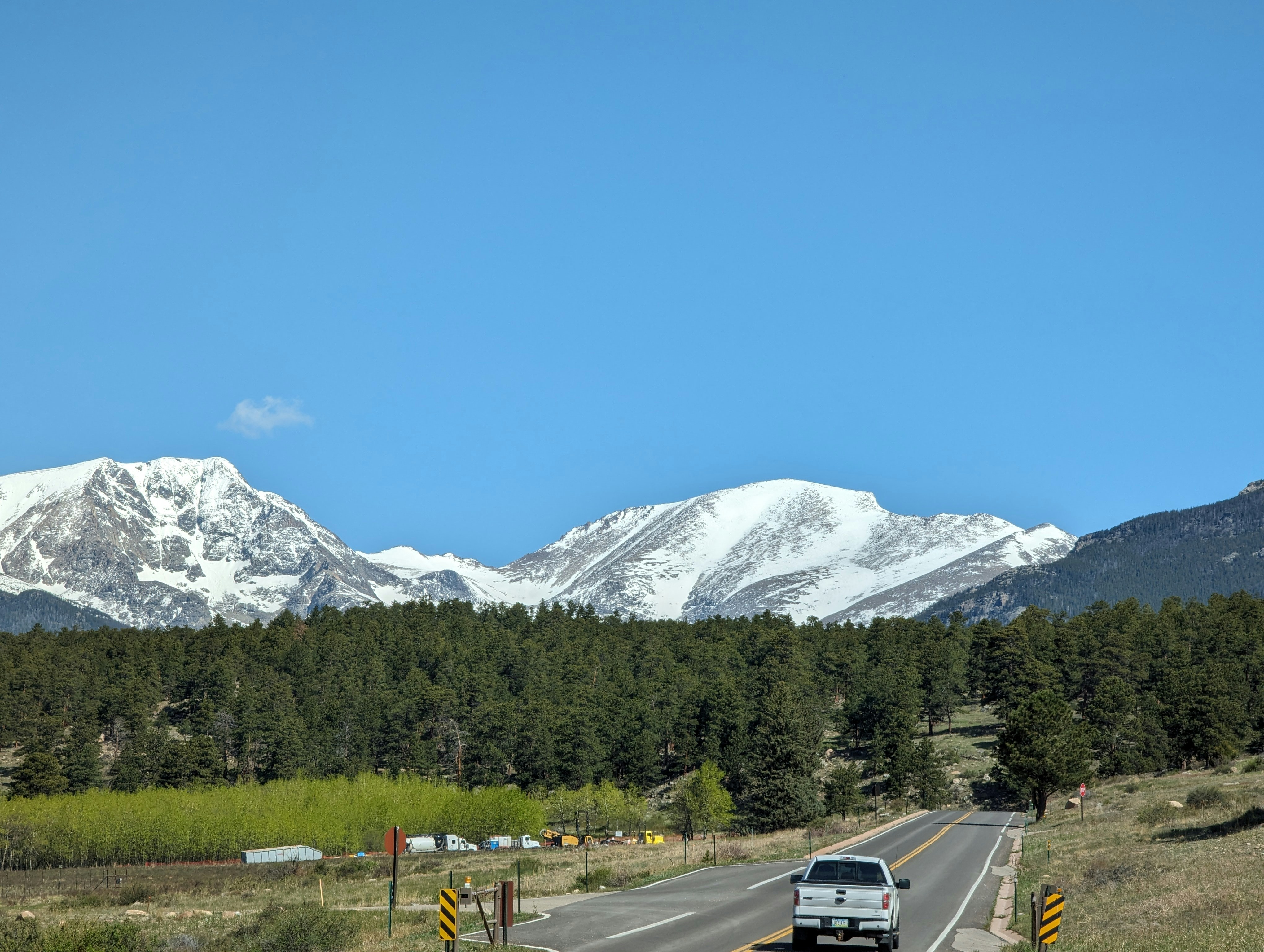 a car driving down a road with mountains in the background