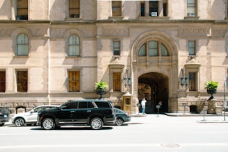 a black suv parked in front of a large building