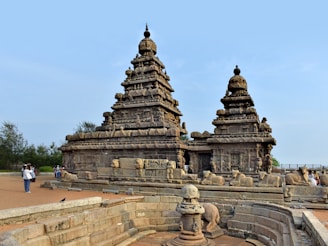 a group of statues on a wall near a body of water
