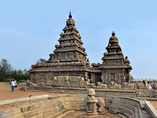 a group of statues on a wall near a body of water