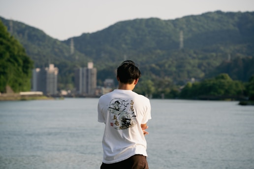 a man standing on the edge of a body of water