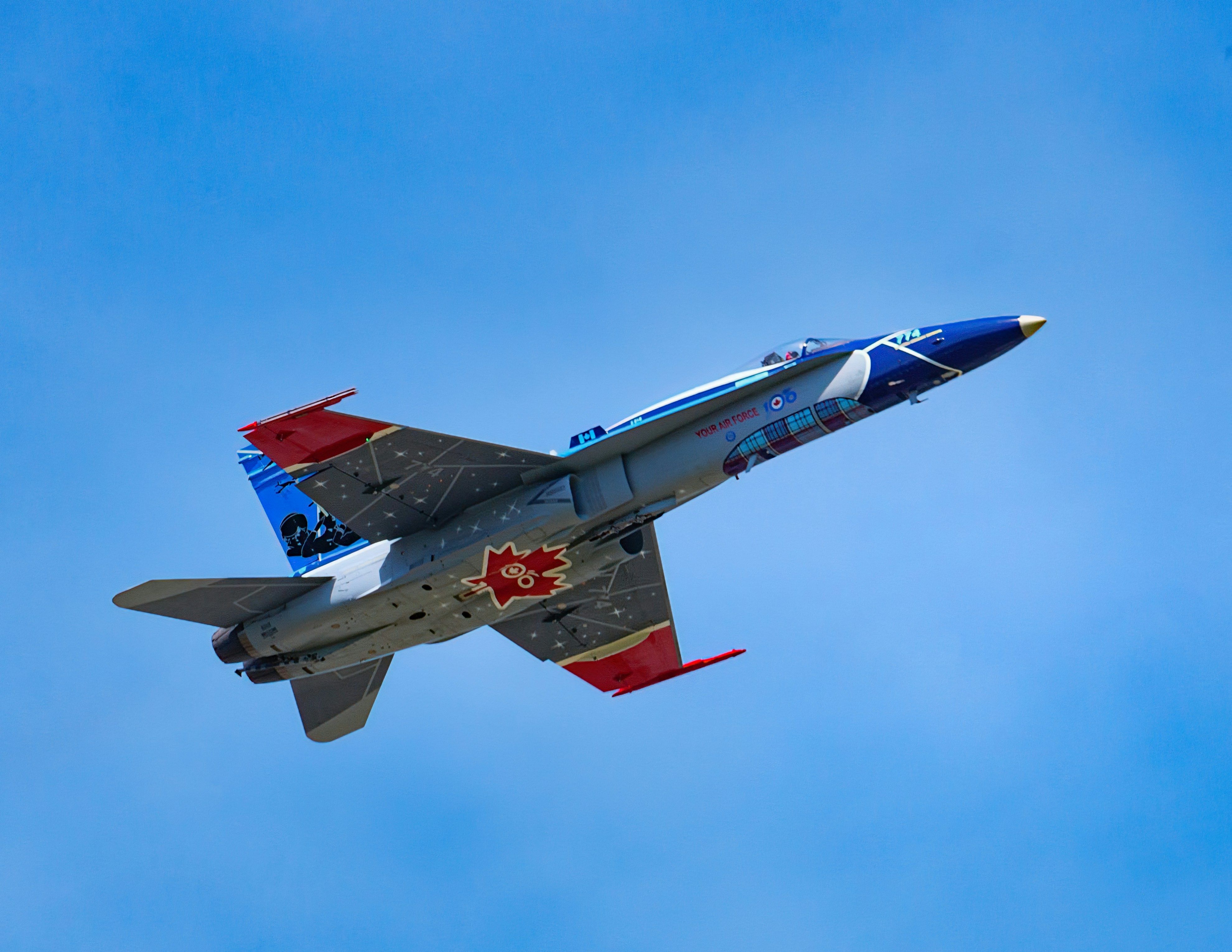 a fighter jet flying through a blue sky