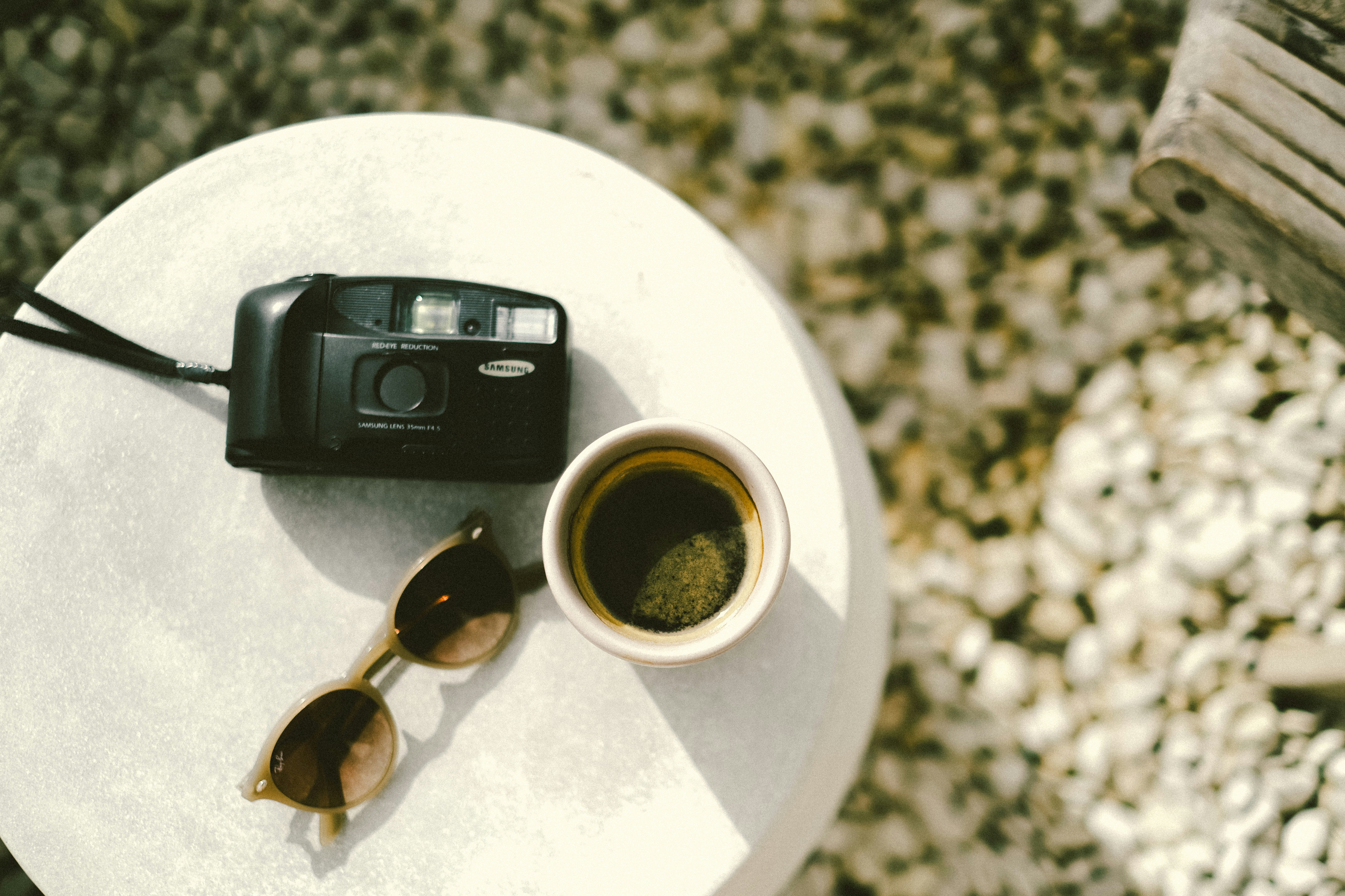 a camera and a cup of coffee on a table