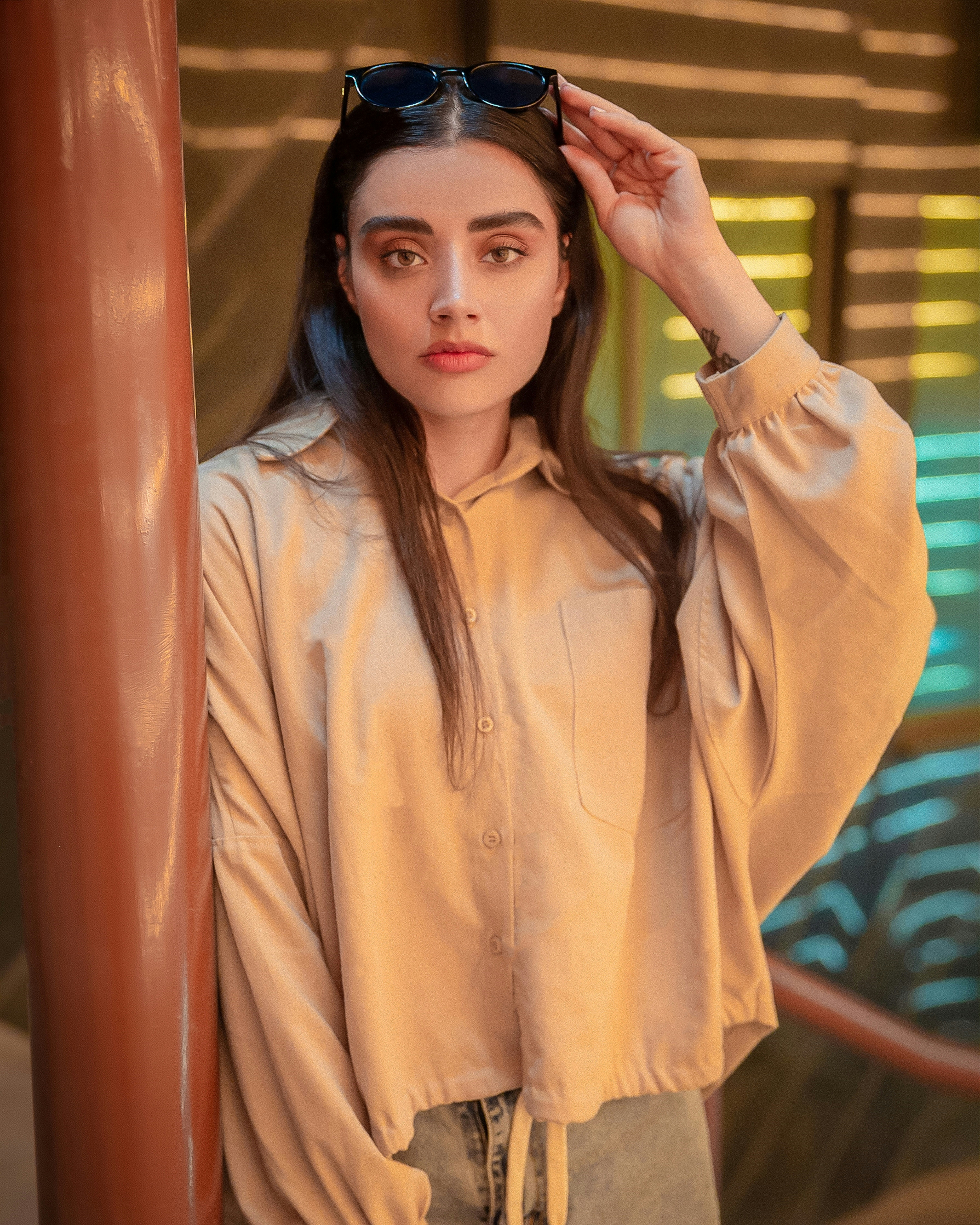 a woman wearing a tan shirt and black sunglasses