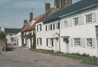 a row of white houses on a cobblestone street