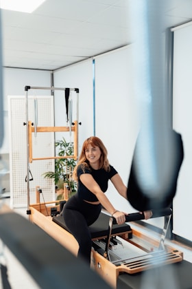 a woman is riding a stationary rowing machine