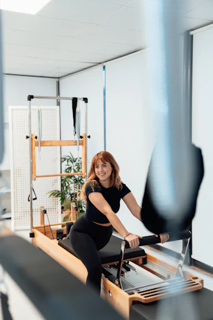 a woman is riding a stationary rowing machine