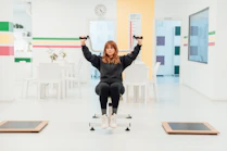 a woman is sitting on a chair with her hands in the air