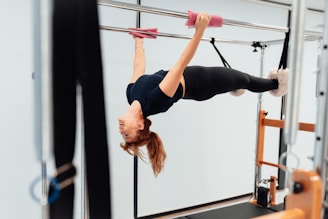 a woman doing a handstand on a pull up bar