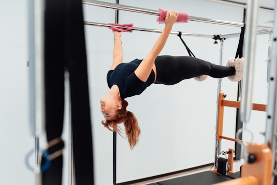 a woman doing a handstand on a pull up bar