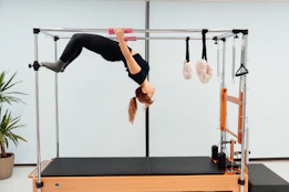 a woman doing a handstand on a pivot machine