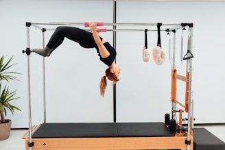 a woman doing a handstand on a pivot machine
