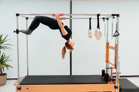 a woman doing a handstand on a pivot machine