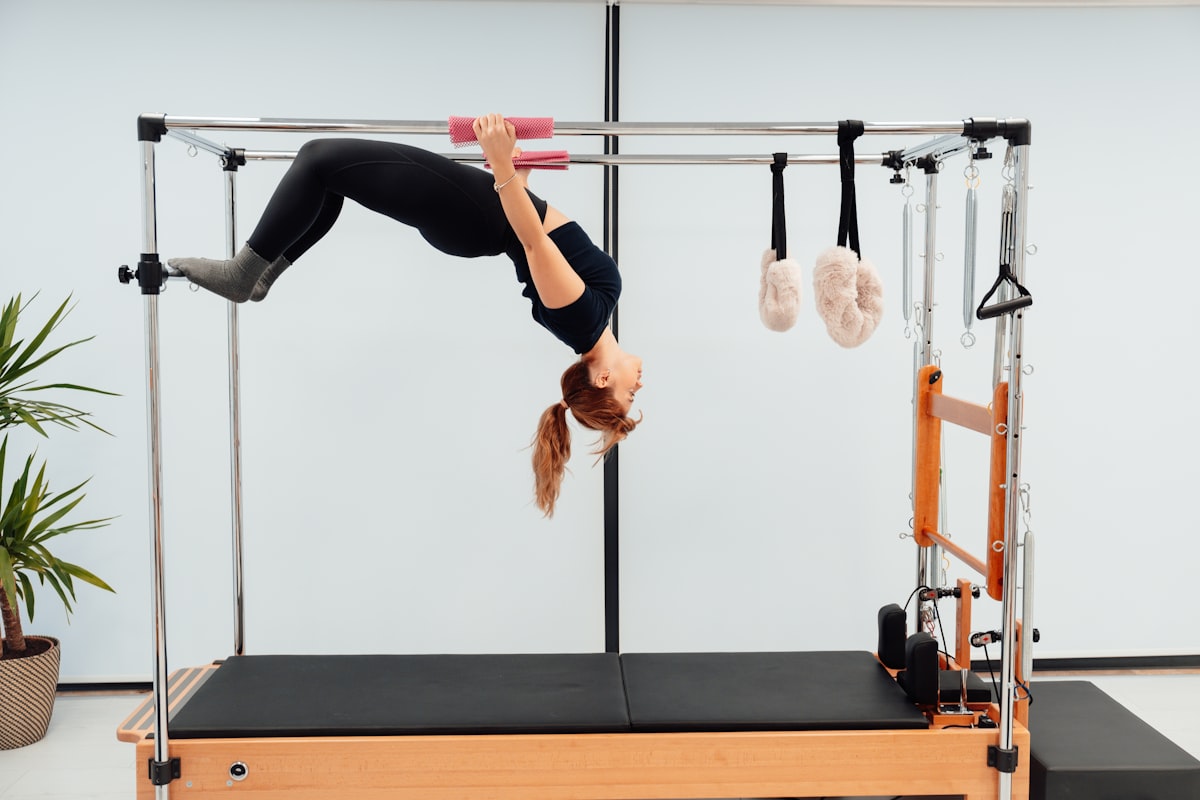 a woman doing a handstand on a pivot machine