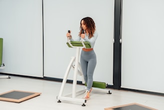 a woman standing on a treadmill holding a cell phone
