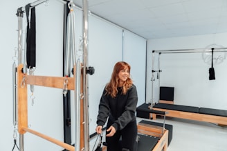 a woman standing in a gym holding a bar