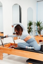 a woman is doing exercises on a rowing machine