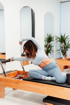 a woman is doing exercises on a rowing machine