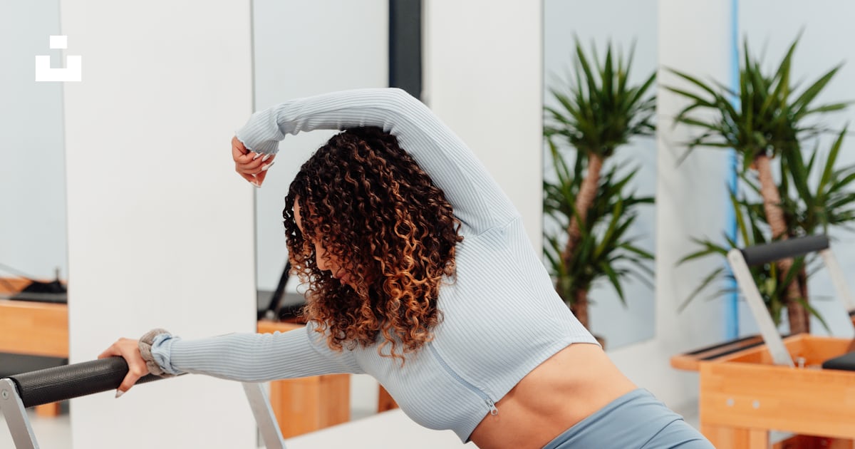 A woman is doing exercises on a rowing machine photo – Free Pilates ...