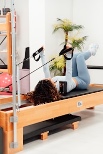 a woman in a gym doing exercises on a rowing machine