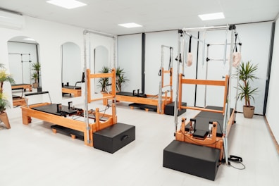 a gym with a row of machines and mirrors