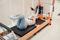 a woman is doing exercises on a rowing machine