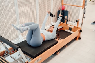 a woman is doing exercises on a rowing machine