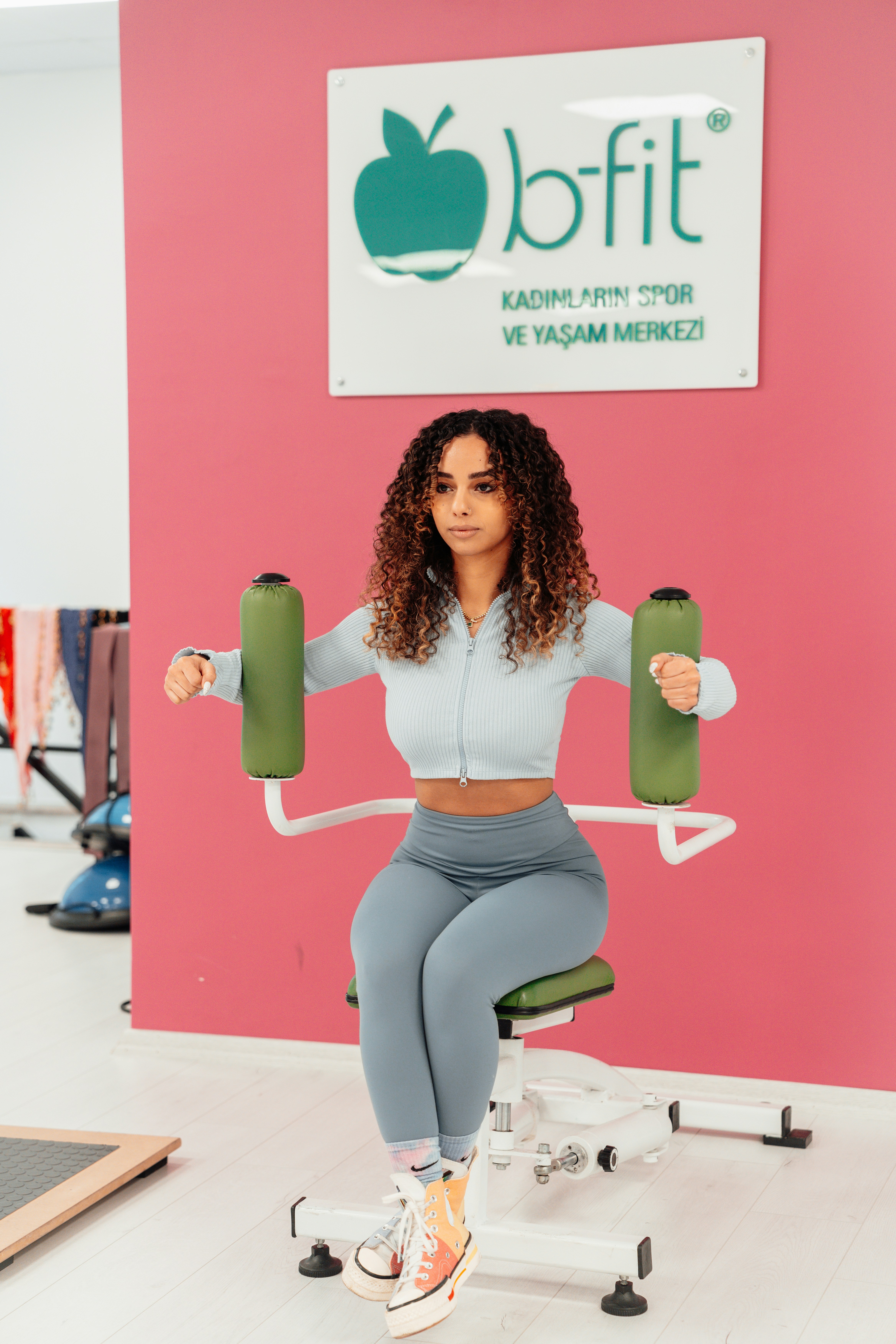 a woman sitting on a chair holding a pair of dumbs