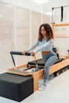 a woman is doing exercises on a rowing machine