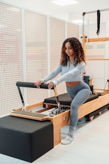 a woman is doing exercises on a rowing machine