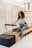a woman is doing exercises on a rowing machine