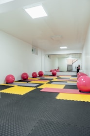 a room filled with exercise mats and exercise balls