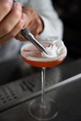 a bartender is mixing a drink in a glass