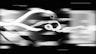 a black and white photo of a train speeding by